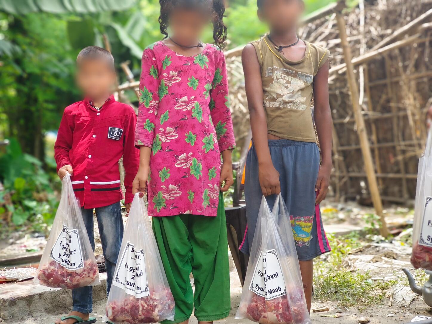 Privacy-protected children receiving buffalo and goat Qurbani meat in Nepal